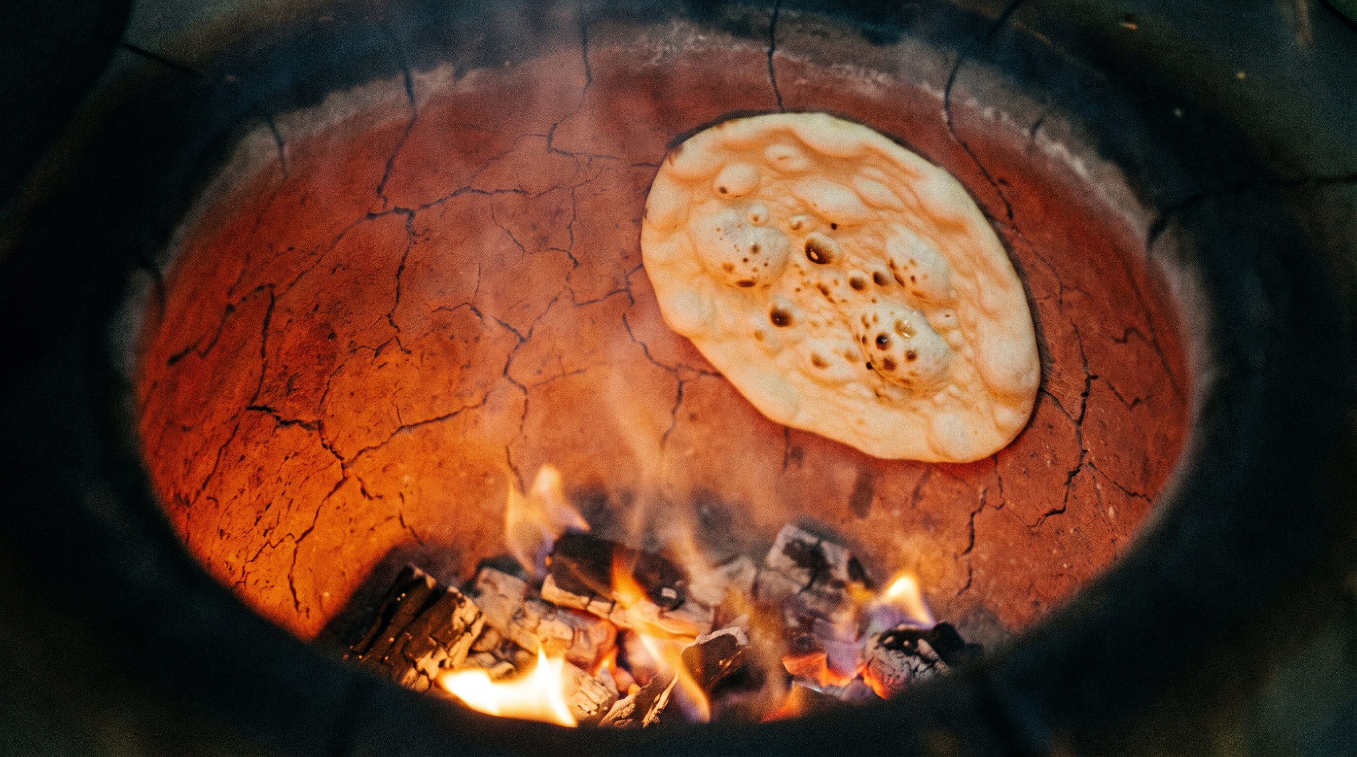 Naan slapped on the tandoor wall